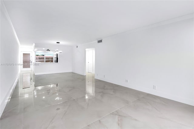 empty room with marble finish floor, visible vents, and baseboards