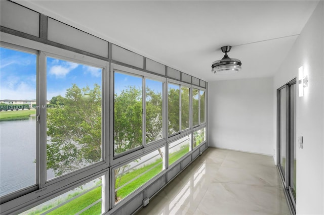 unfurnished sunroom featuring a water view