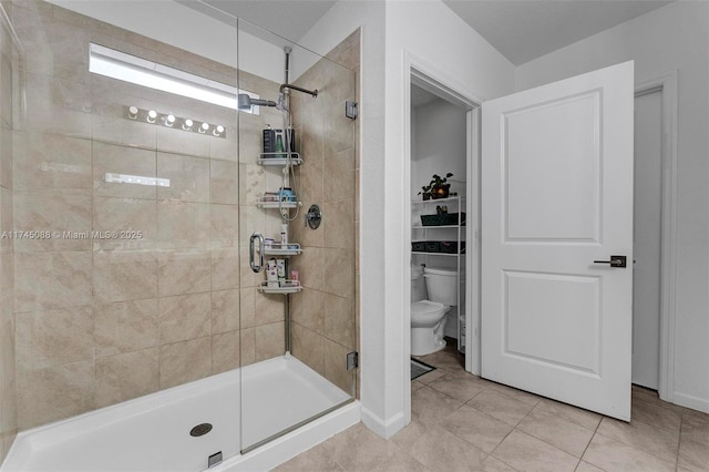 full bathroom featuring a shower stall, toilet, and tile patterned floors