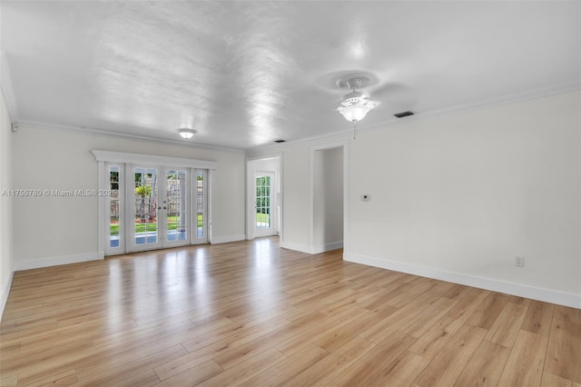 unfurnished room with baseboards, visible vents, crown molding, french doors, and light wood-style floors