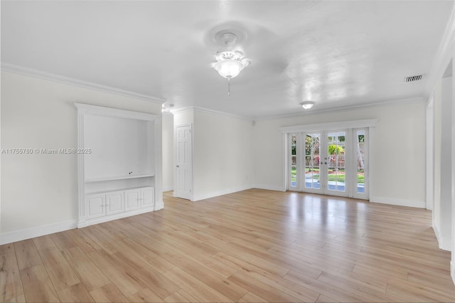 empty room featuring ornamental molding, french doors, visible vents, and light wood finished floors