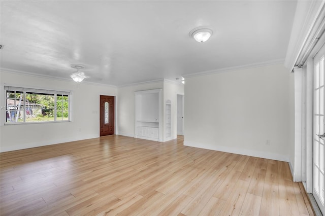 unfurnished living room featuring ornamental molding, light wood finished floors, and baseboards