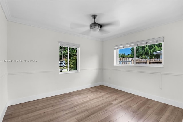 unfurnished room featuring ceiling fan, plenty of natural light, wood finished floors, and baseboards