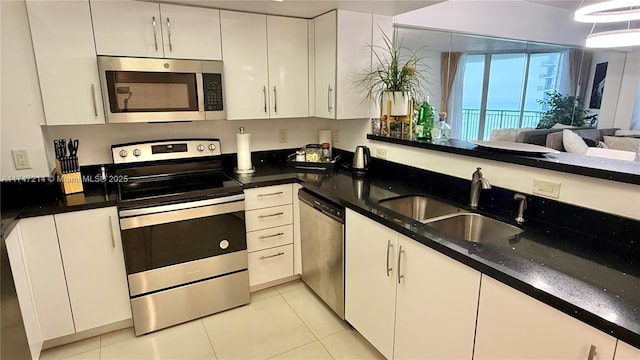 kitchen with stainless steel appliances, white cabinets, a sink, and light tile patterned floors