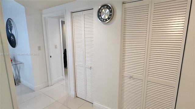 hallway featuring light tile patterned floors and baseboards