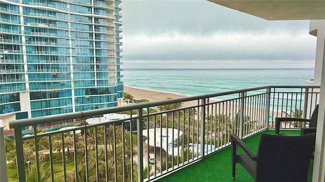 balcony with a water view and a beach view