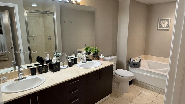 full bathroom with toilet, a stall shower, a sink, and tile patterned floors