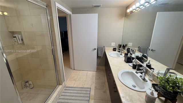 bathroom featuring a shower stall, visible vents, a sink, and tile patterned floors