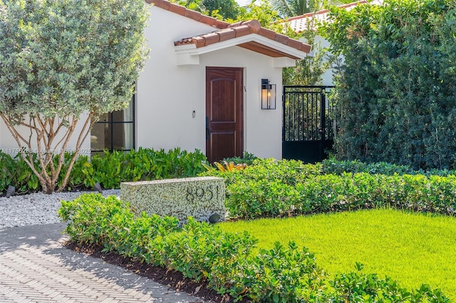 property entrance with a tiled roof and stucco siding