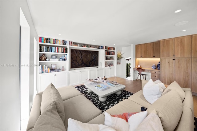 living room with wood finished floors, built in features, and recessed lighting