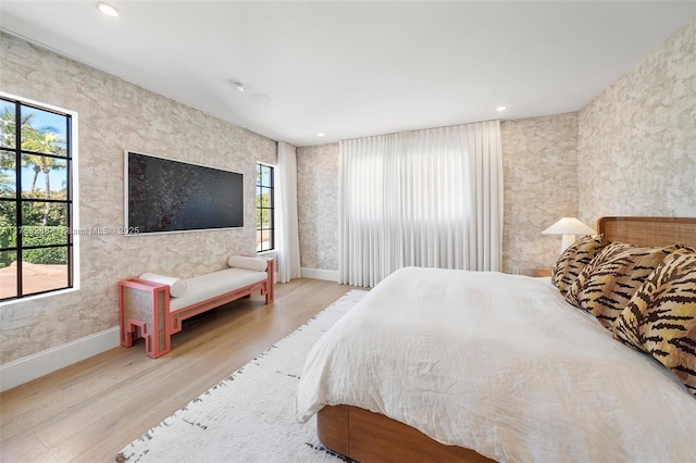 bedroom featuring multiple windows, wood finished floors, and baseboards