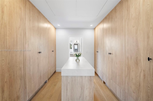 corridor featuring light wood-type flooring and attic access