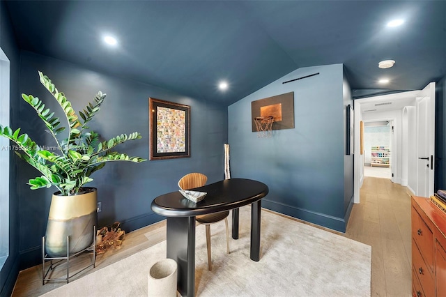 office featuring lofted ceiling, baseboards, and wood finished floors