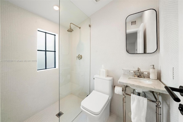 bathroom with visible vents, a sink, toilet, and a walk in shower