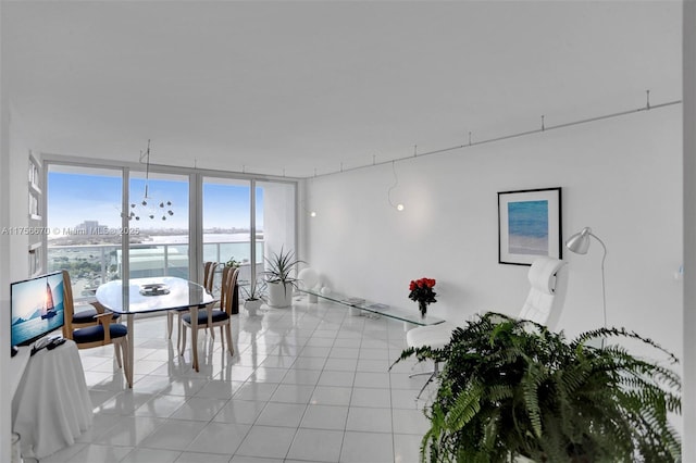 dining area with a water view, light tile patterned floors, and expansive windows