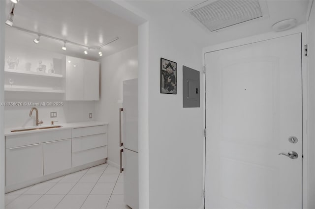 kitchen with electric panel, white cabinets, light countertops, open shelves, and a sink