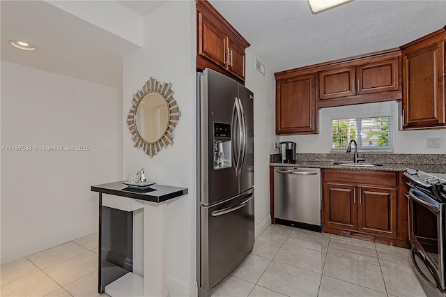 kitchen featuring light tile patterned floors, visible vents, dark stone counters, stainless steel appliances, and a sink