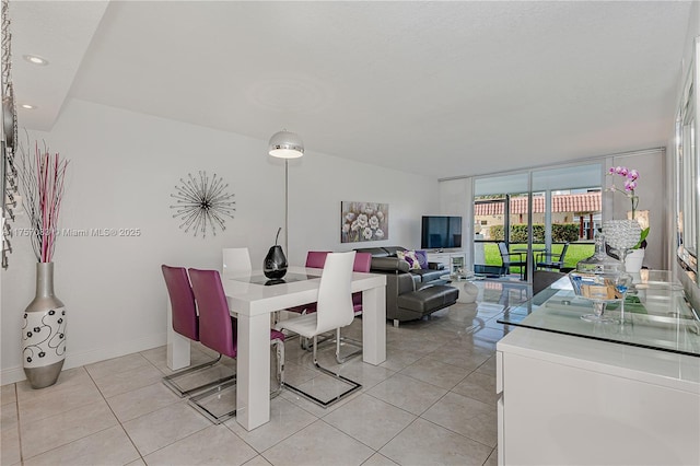 dining room featuring a wall of windows, recessed lighting, baseboards, and light tile patterned floors