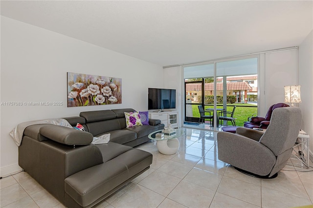 living room featuring a wall of windows, baseboards, and light tile patterned floors