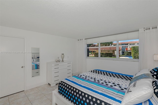 bedroom featuring a textured ceiling and light tile patterned flooring