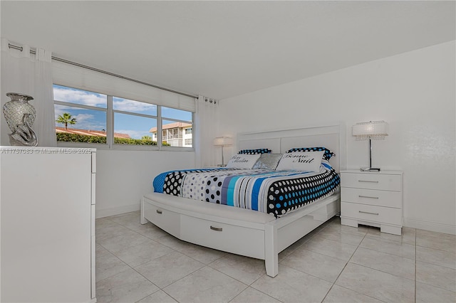 bedroom with light tile patterned flooring and baseboards