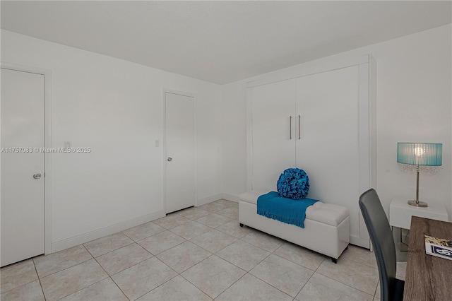 unfurnished room with light tile patterned floors and baseboards