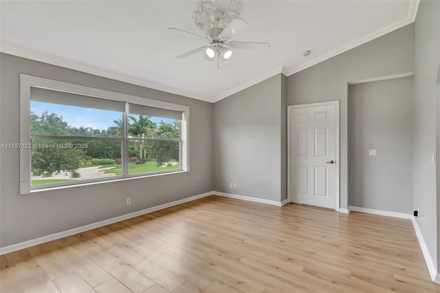 unfurnished room featuring crown molding, light wood finished floors, a ceiling fan, vaulted ceiling, and baseboards