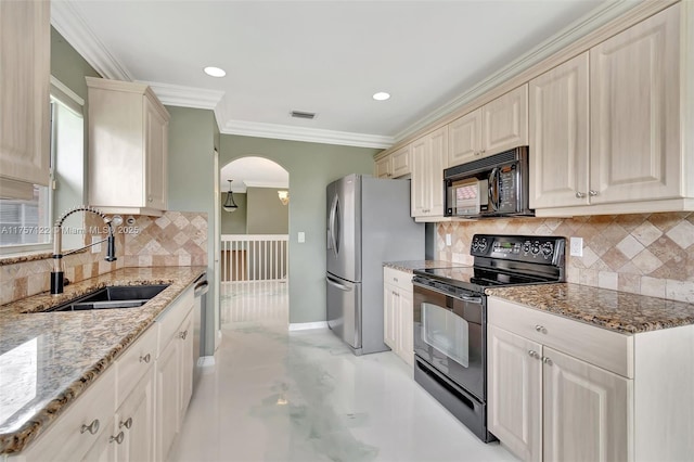 kitchen featuring light stone counters, visible vents, ornamental molding, a sink, and black appliances