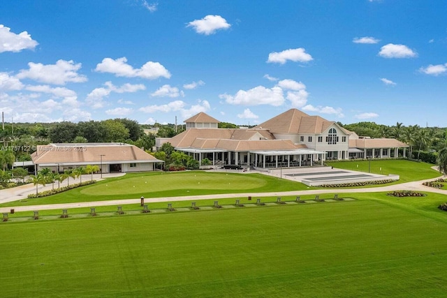 rear view of house with view of golf course and a lawn