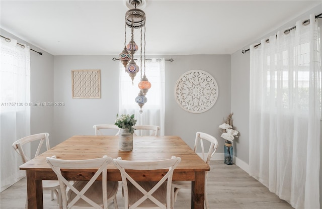 dining area with light wood-style flooring and baseboards