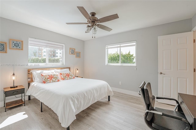 bedroom with light wood-style floors, ceiling fan, and baseboards