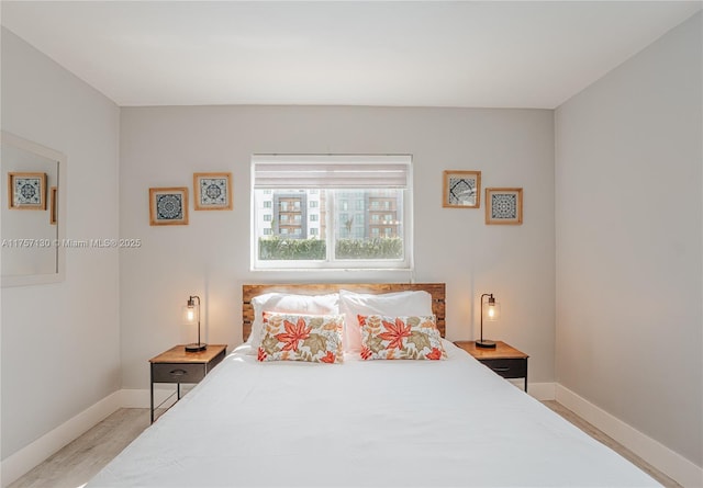 bedroom with baseboards and wood finished floors