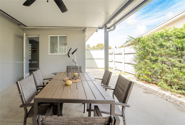 view of patio featuring outdoor dining space, fence, and ceiling fan