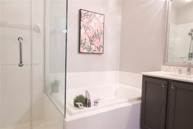 bathroom featuring a stall shower, a garden tub, and vanity