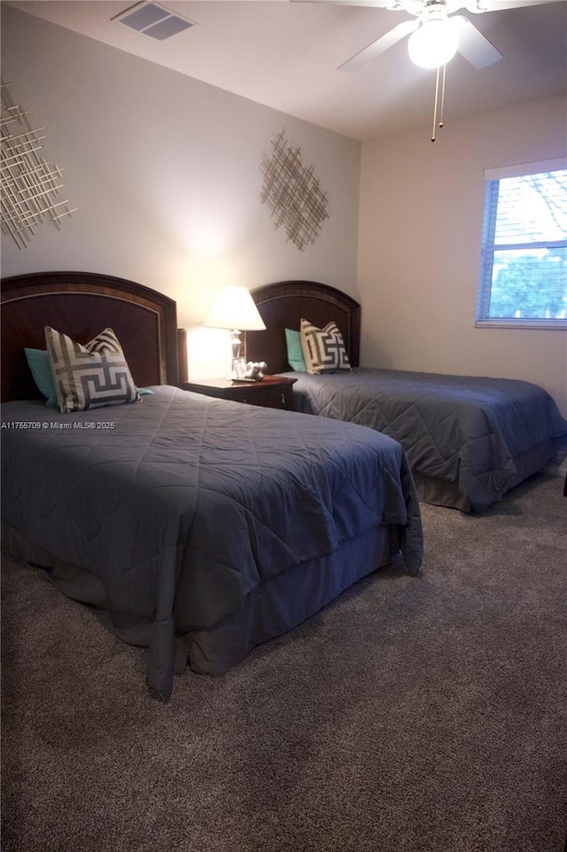 carpeted bedroom featuring a ceiling fan and visible vents