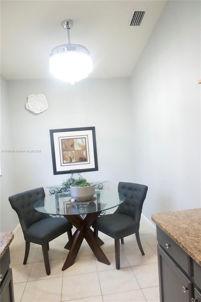 dining area featuring light tile patterned floors, baseboards, and visible vents