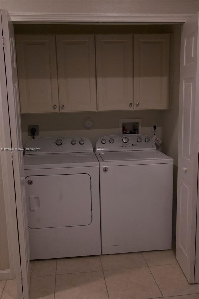 washroom featuring light tile patterned floors, cabinet space, and washer and dryer