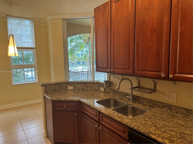 kitchen with light tile patterned floors, ornamental molding, dark stone countertops, a peninsula, and a sink