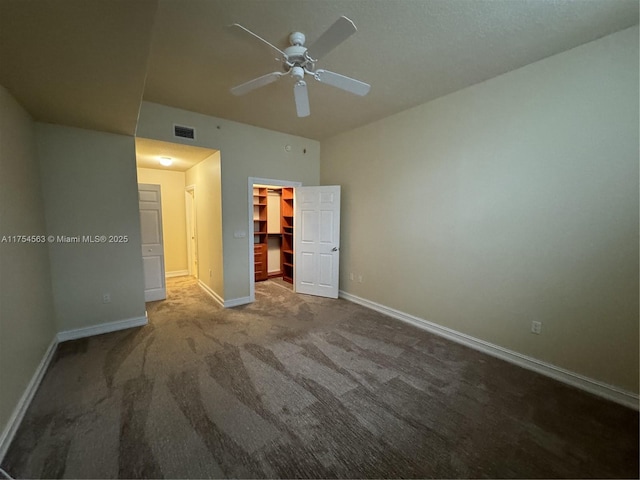 unfurnished bedroom with baseboards, visible vents, carpet, a spacious closet, and a closet