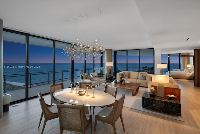 dining space featuring a wall of windows, wood finished floors, and a chandelier