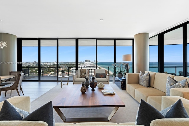 living room featuring light wood-style floors, expansive windows, and a water view