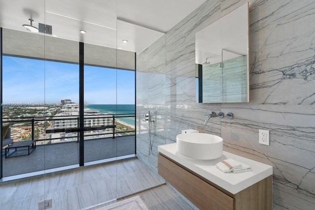 bathroom featuring stone wall, floor to ceiling windows, tile walls, and vanity