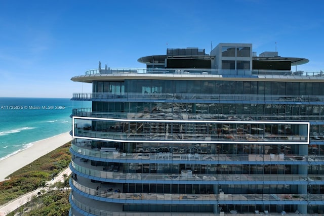 view of property with a water view and a view of the beach