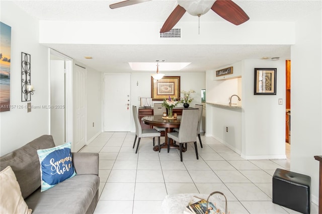 dining space with visible vents, a textured ceiling, baseboards, and light tile patterned flooring