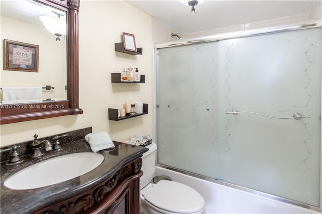 full bathroom featuring shower / bath combination with glass door, vanity, and toilet