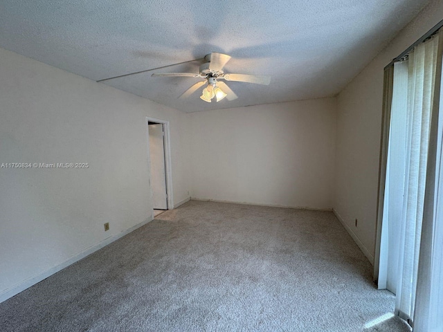 unfurnished room featuring ceiling fan, a textured ceiling, and light colored carpet