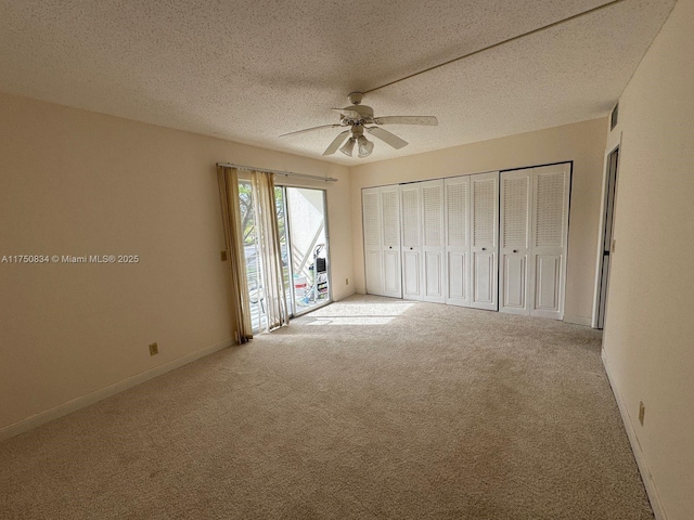 unfurnished bedroom with a textured ceiling, ceiling fan, baseboards, access to exterior, and carpet