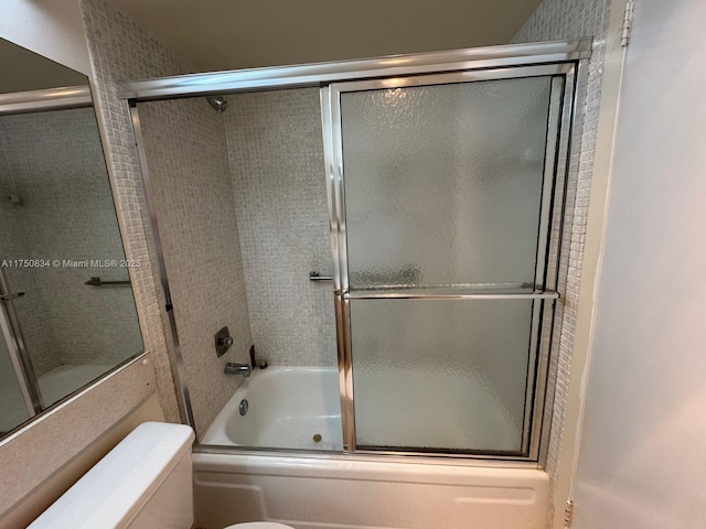 bathroom with combined bath / shower with glass door and toilet