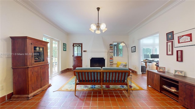 living area featuring a large fireplace, a notable chandelier, baseboards, and crown molding