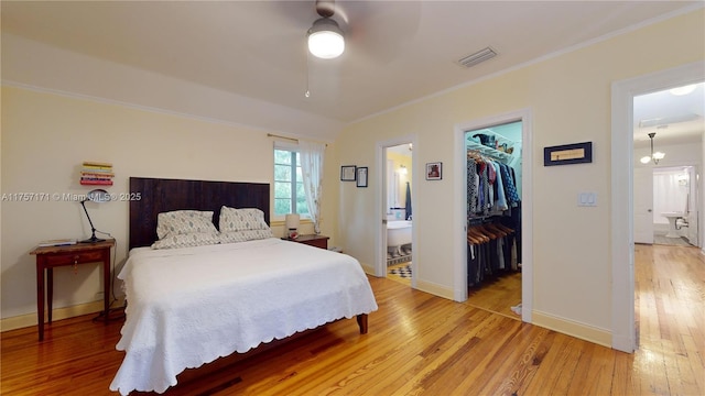 bedroom featuring visible vents, baseboards, light wood-style floors, a spacious closet, and a closet